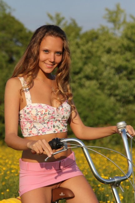 Голая девка на велосипеде позирует в поле - фото эротика.